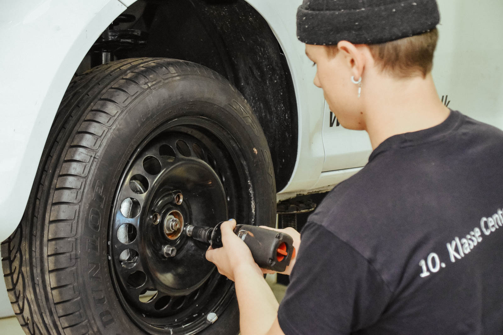 En elev monterer hjul på en bil