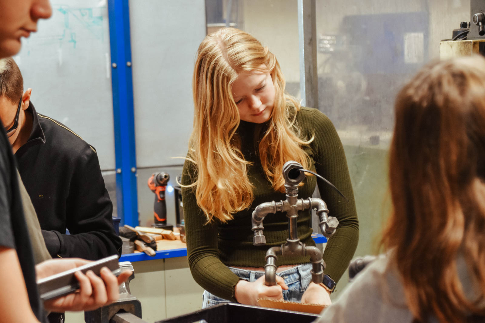 Elever laver metalmænd af rør og møtrikker i værkstedet